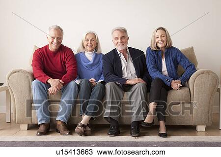 Stock Image - Two senior couples on sofa. Fotosearch