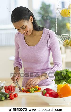 Woman chopping vegetables in kitchen View Large Photo Image Stock Image - Woman chopping vegetables in kitchen. Fotosearch