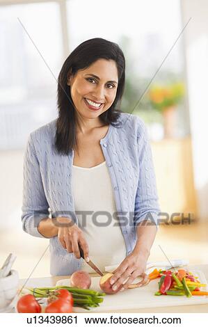 Stock Image - Woman cutting vegetables. Fotosearch