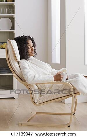 Woman drinking coffee in armchair in morning View Large Photo Image Stock Photo - Woman drinking coffee in armchair in morning. Fotosearch