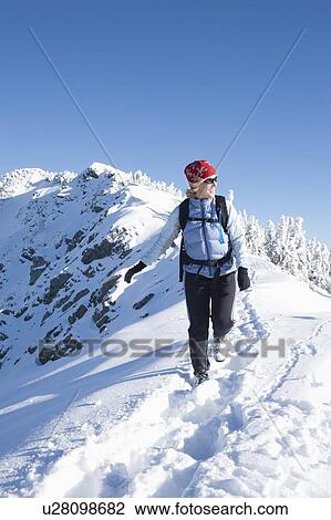 Stock Image - Woman hiking in winter scenery. Fotosearch