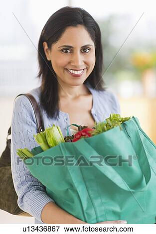Woman holding bag of fresh vegetables View Large Photo Image Stock Photo - Woman holding bag of fresh vegetables. Fotosearch