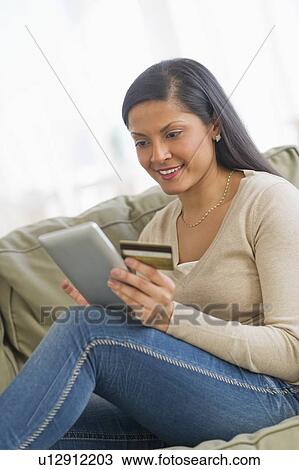 Stock Image - Woman holding credit card and digital tablet. Fotosearch