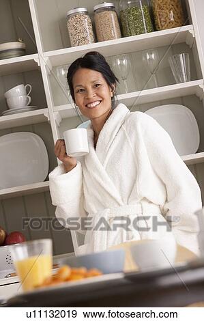 Stock Photo - Woman in bathrobe with coffee cup. Fotosearch