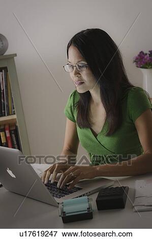Stock Photo - Woman in glasses working with laptop. Fotosearch