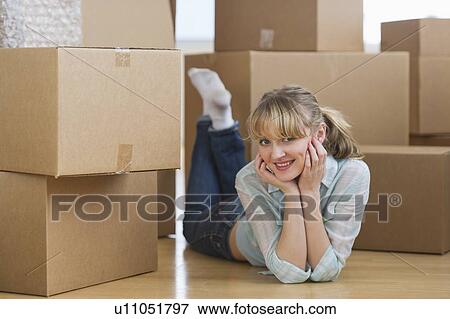 Stock Photo - Woman lying among cardboard boxes during relocation. Fotosearch