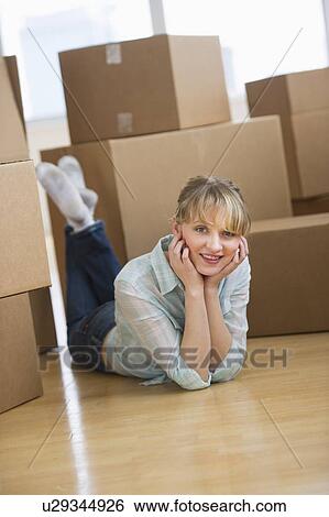 Stock Photograph - Woman lying among cardboard boxes during relocation. Fotosearch