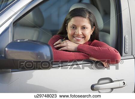Stock Image - Woman sitting in her new car. Fotosearch