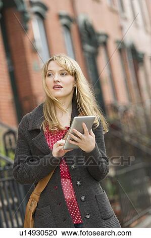 Woman using digital tablet on street View Large Photo Image Stock Image - Woman using digital tablet on street. Fotosearch