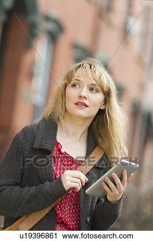 Woman using digital tablet on street View Large Photo Image Stock Image - Woman using digital tablet on street. Fotosearch