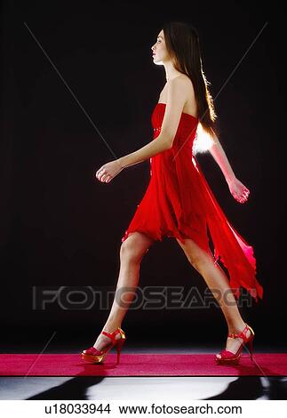 Picture - Woman wearing red dress on catwalk. Fotosearch