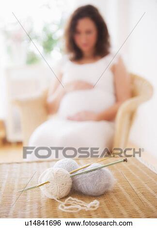Wool and knitting needles with pregnant woman in background View Large Photo Image Stock Photograph - Wool and knitting needles with pregnant woman in background. Fotosearch