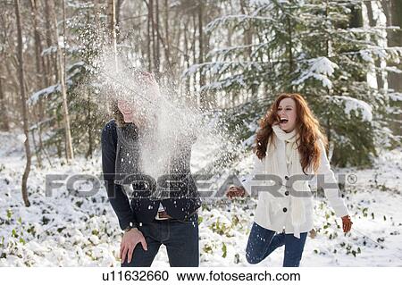 Stock Image - Young couple are having snowball fight. Fotosearch
