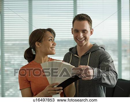 Stock Image - Young couple choosing color from color swatch. Fotosearch