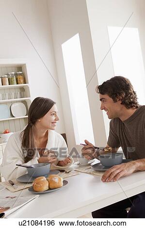 Stock Photograph - Young couple eating breakfast. Fotosearch