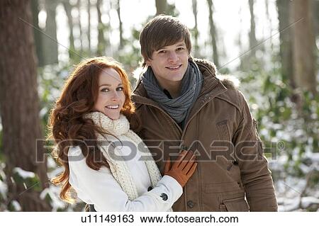 Stock Image - Young couple embracing in winter scenery. Fotosearch