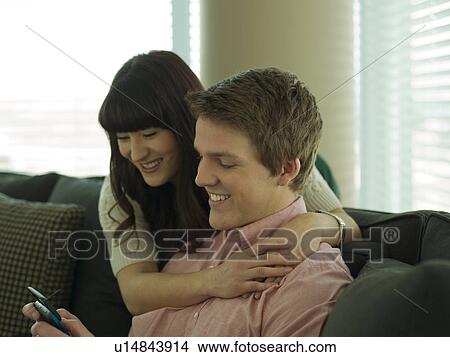 Young couple smiling in their home View Large Photo Image Picture - Young couple smiling in their home. Fotosearch