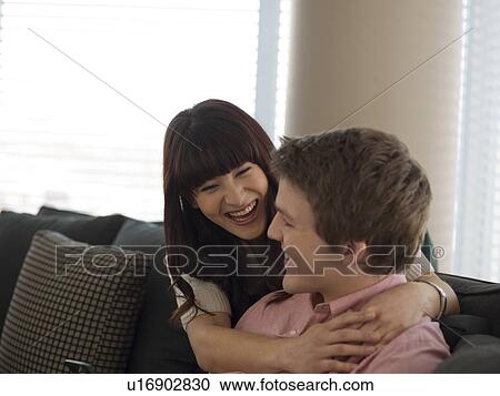 Young couple smiling in their home View Large Photo Image Stock Image - Young couple smiling in their home. Fotosearch