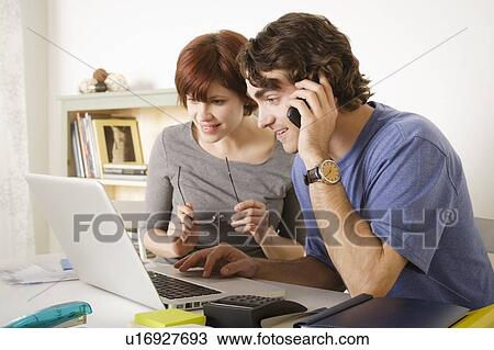 Young couple using laptop View Large Photo Image Stock Image - Young couple using laptop . Fotosearch