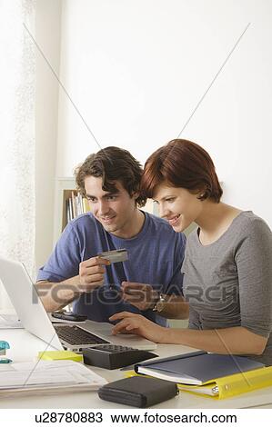 Stock Image - Young couple using laptop . Fotosearch