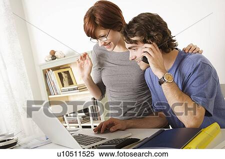 Young couple using laptop View Large Photo Image Stock Photography - Young couple using laptop . Fotosearch