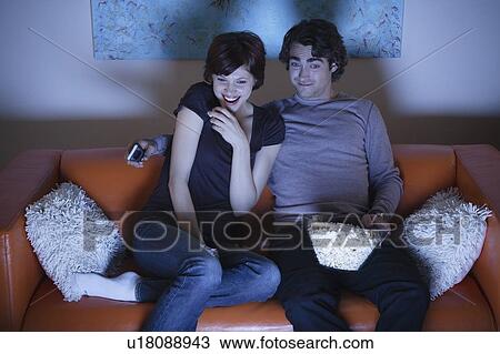 Stock Image - Young couple watching TV. Fotosearch