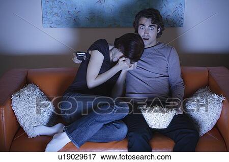 Stock Photo - Young couple watching TV. Fotosearch