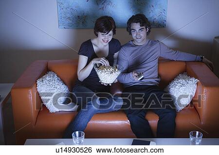 Young couple watching TV View Large Photo Image Stock Photograph - Young couple watching TV. Fotosearch
