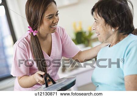 Young female nurse attending patient View Large Photo Image Stock Image - Young female nurse attending patient. Fotosearch