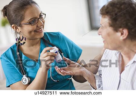 Young female nurse attending patient View Large Photo Image Stock Image - Young female nurse attending patient. Fotosearch