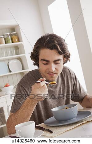Stock Image - Young man eating. Fotosearch