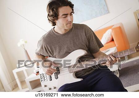 Stock Image - Young man playing electric guitar. Fotosearch