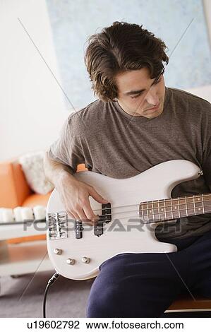 Young man playing electric guitar View Large Photo Image Stock Image - Young man playing electric guitar. Fotosearch