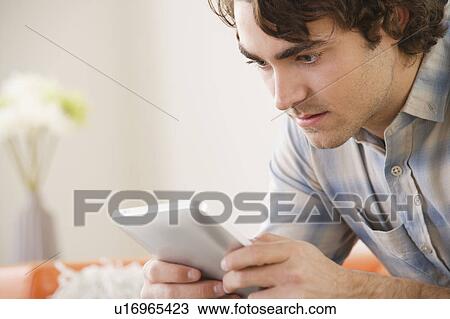 Stock Image - Young man using digital tablet. Fotosearch