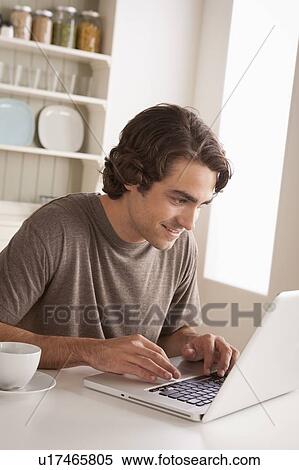Stock Photography - Young man using laptop. Fotosearch