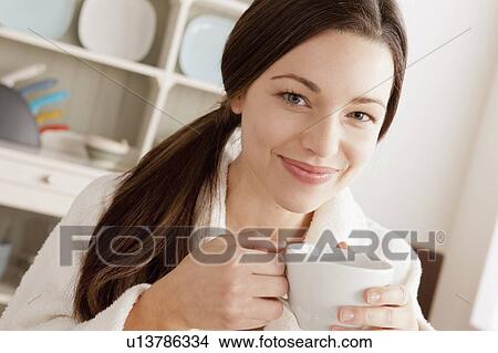 Picture - Young smiling woman holding cup. Fotosearch