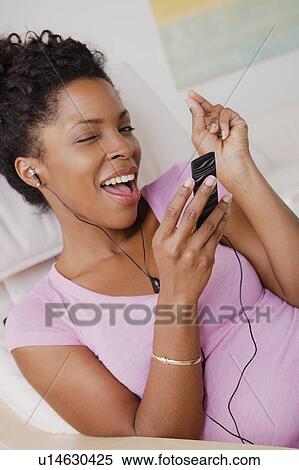 Young smiling woman listening music View Large Photo Image Stock Photography - Young smiling woman listening music. Fotosearch