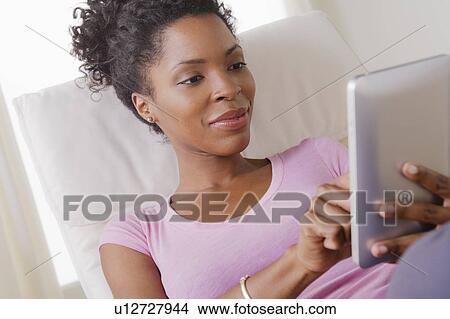 Young smiling woman using digital tablet View Large Photo Image Picture - Young smiling woman using digital tablet. Fotosearch