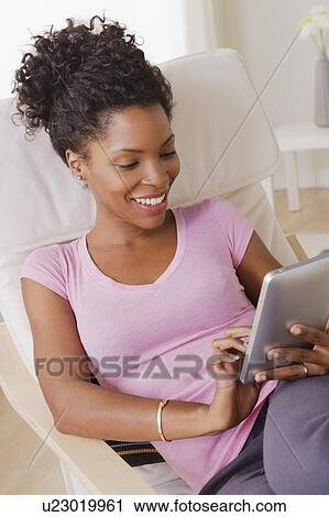 Young smiling woman using digital tablet View Large Photo Image Stock Image - Young smiling woman using digital tablet. Fotosearch