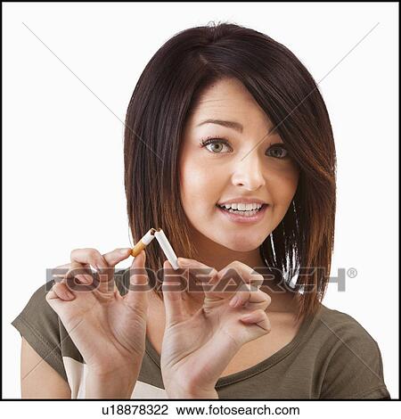 Stock Image - Young woman breaking cigarette. Fotosearch