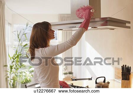 Stock Photo - Young woman cleaning kitchen. Fotosearch