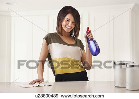 Stock Photo - Young woman cleaning kitchen. Fotosearch