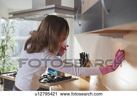 Young woman cleaning the kitchen View Large Photo Image Stock Image - Young woman cleaning the kitchen. Fotosearch
