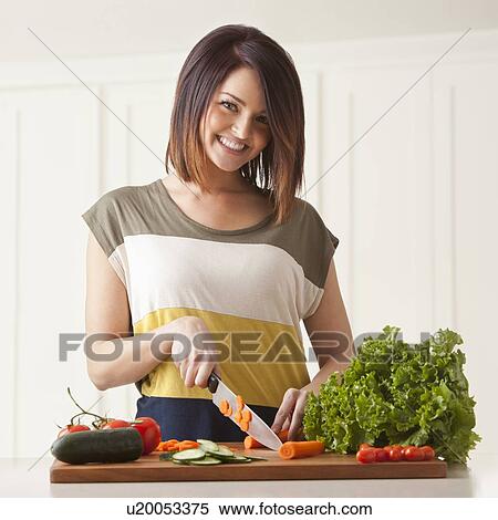 Young woman cutting vegetables View Large Photo Image Stock Photography - Young woman cutting vegetables. Fotosearch