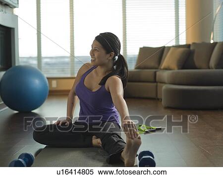 Stock Photography - Young woman exercising at home. Fotosearch