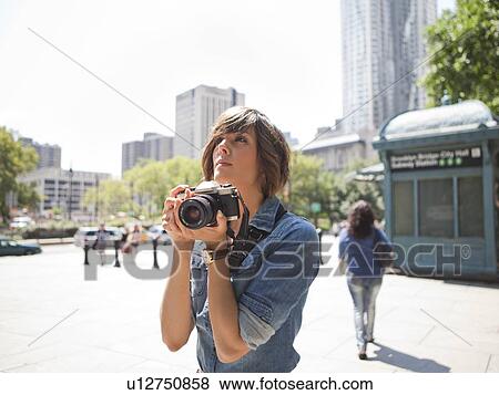 Young woman holding photo camera View Large Photo Image Stock Photo - Young woman holding photo camera. Fotosearch