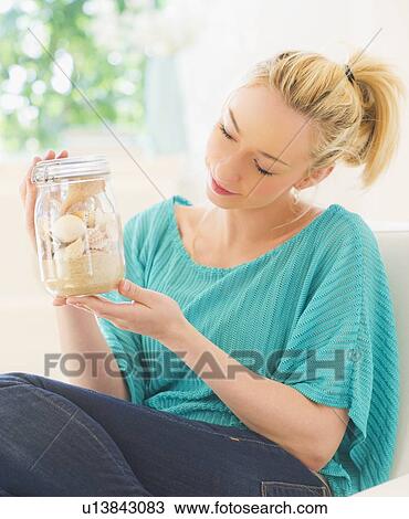Young woman holding shells in jar View Large Photo Image Stock Image - Young woman holding shells in jar. Fotosearch