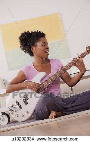 Picture - Young woman playing electric guitar. Fotosearch