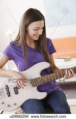 Picture - Young woman playing electric guitar. Fotosearch
