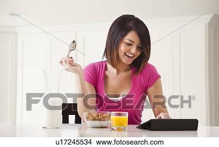 Young woman preparing breakfast View Large Photo Image Picture - Young woman preparing breakfast. Fotosearch